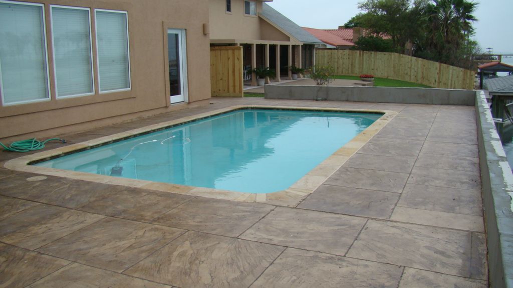 NEW NATURAL STONE COPING, EARTH TONE TILE and STAMPED CONRETE DECK